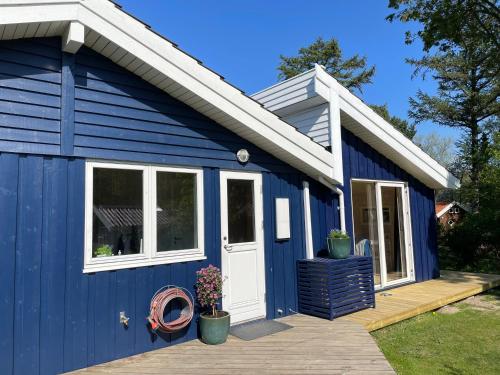 a blue tiny house with a white door at Vejby Strand cabin near beach & Heatherhill - 101 m2 in Vejby