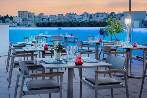 a restaurant with tables and chairs on a roof at NH Nice in Nice