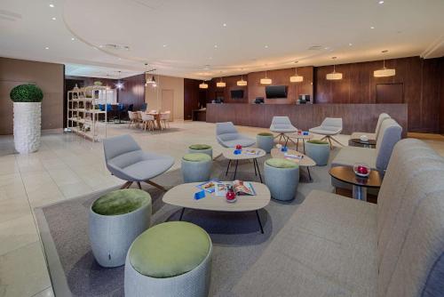 a lobby with tables and chairs and a waiting room at NH Nice in Nice