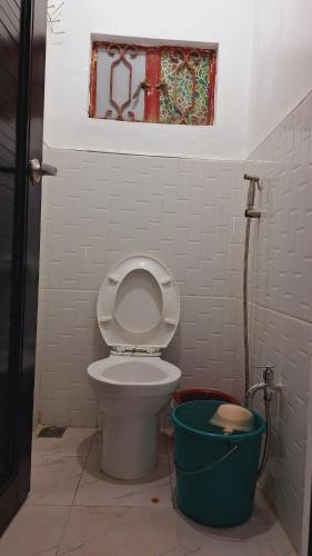a bathroom with a toilet and a window and a bucket at Bahay Bakasyunan in Lubao near Pradera Verde in Lubao