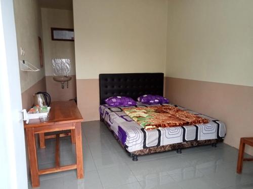 a bedroom with a bed and a wooden table at Tengger Bromo Villa in Ngadisari