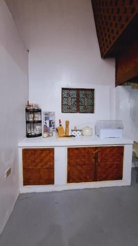 a kitchen with wooden cabinets and a counter top at Bahay Bakasyunan in Lubao near Pradera Verde in Lubao