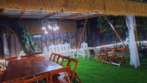 a dining room with a long table and chairs at Bahay Bakasyunan in Lubao near Pradera Verde in Lubao