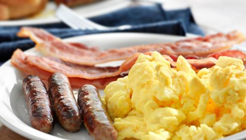 a plate of breakfast food with sausage and bacon at Copthorne King's Hotel Singapore in Singapore
