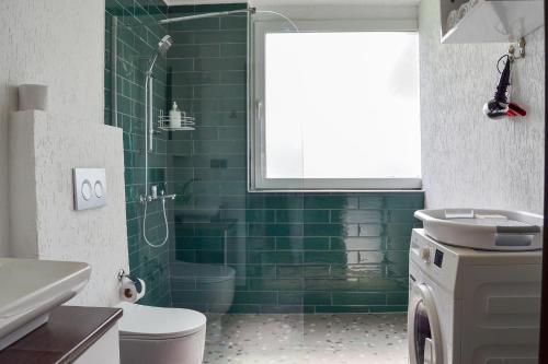 a green tiled bathroom with a toilet and a shower at Loca Centre Suites in Bodrum City