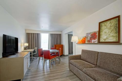 a living room with a couch and a table at Country Inn & Suites by Radisson, New Orleans I-10 East, LA in New Orleans