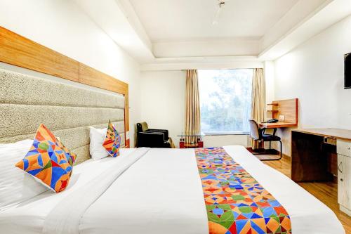 a hotel room with a large bed and a desk at The Sky Comfort, Ahmedabad in Ahmedabad
