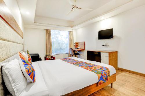a bedroom with a bed and a television in it at The Sky Comfort, Ahmedabad in Ahmedabad