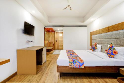 a hotel room with a bed and a television at The Sky Comfort, Ahmedabad in Ahmedabad