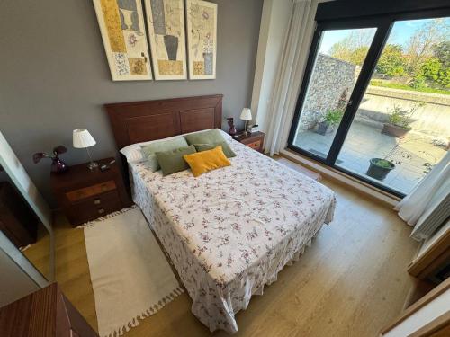 a bedroom with a bed and a large window at Chalet los Jardines in Polanco