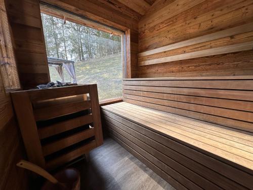 a sauna with a window in a wooden cabin at Alpine Mountain Chalet in San Vigilio Di Marebbe
