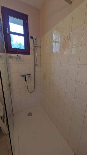 La salle de bains est pourvue d'une douche et d'une fenêtre. dans l'établissement Maison de campagne - Proche Aubenas et Vals les Bains, à Saint-Julien-du-Serre