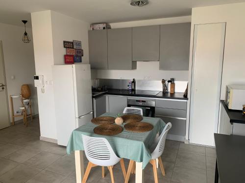 une cuisine avec une table et des chaises vertes dans l'établissement Appartement 4p 42m2 proche des plages, à La Crau