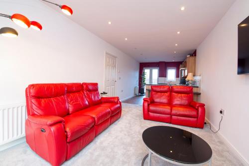 a living room with a red couch and a table at Durham 2-Bed Apartment in Durham