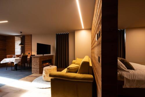 a hotel room with a bed and a dining room at Ca' Leonardi II - Ledro in Tiarno di Sotto