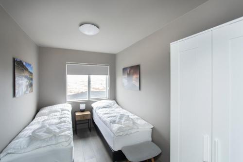 a bedroom with two beds and a window at The Apartment at Reykjanesviti in Hafnir