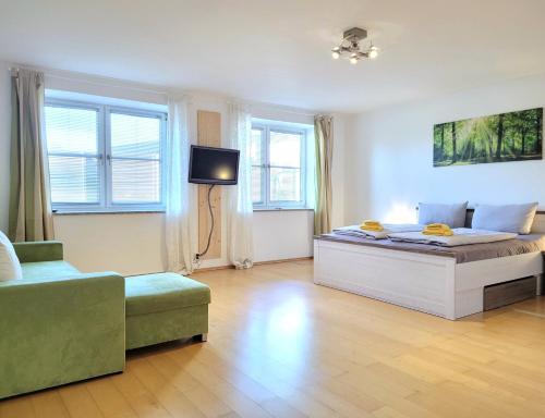 a bedroom with a bed and a tv and a couch at Wohnraum by Steidle in Buxheim