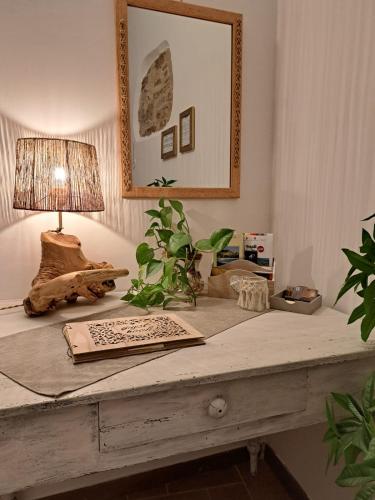 a table with a lamp and plants on it at Nel vicolo dei Baci - Casa vacanze al Bacio in Spello