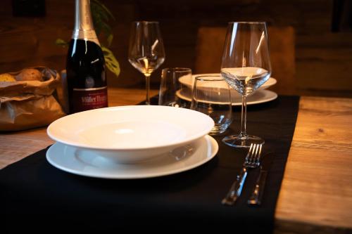 a table with two glasses of wine and a plate at Ca' Leonardi II - Ledro in Tiarno di Sotto