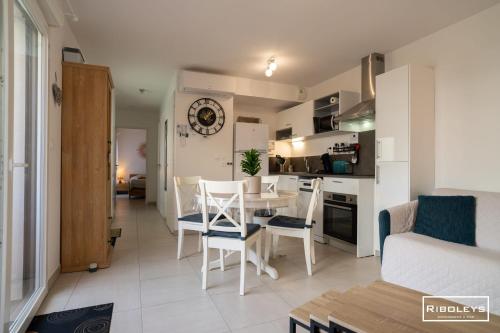 a kitchen and living room with a table and chairs at Villa T3 à 400m de la plage avec piscine in Vias