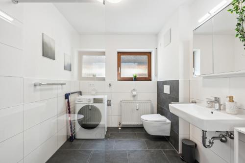 a white bathroom with a toilet and a sink at Sali Homes Weingenuss Eichbrunnen - Zentral in Obersulm