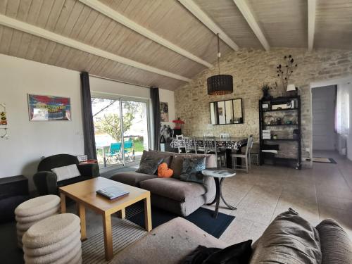 un salon avec un canapé et une table dans l'établissement Family home near beach surf forest and marshes, à Longeville-sur-Mer