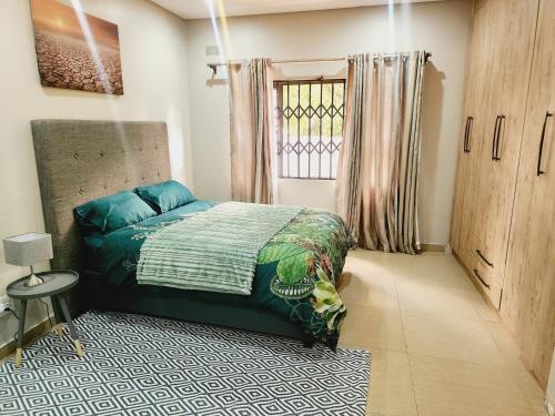 a bedroom with a bed and a window at Eastern Road Executive Suites in Harare