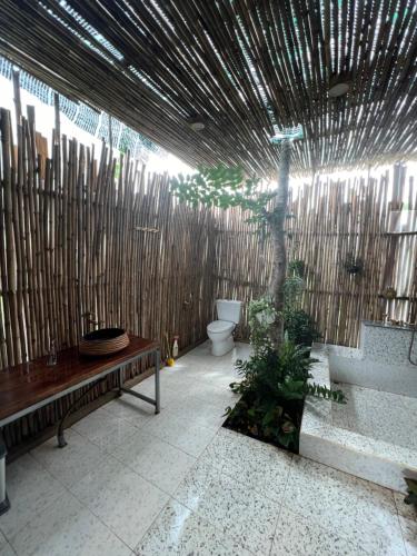 a patio with a bench and a bamboo fence at Rao Retreat in Ấp Xuân Khai