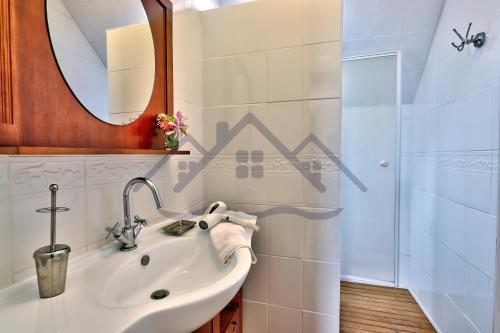 a bathroom with a sink and a shower at LocaLise - M6A - Ty Heol - Maison de vacances à quelques pas du port et des plages - jardin avec terrasse entièrement clos - wifi inclus in Tréffiagat