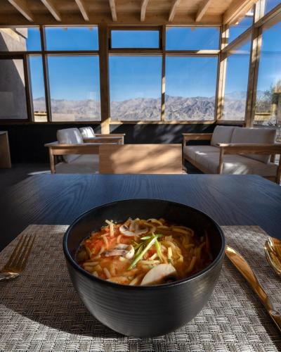 a bowl of food sitting on a table at The Postcard in The Himalayan Willows, Stok, Leh in Leh
