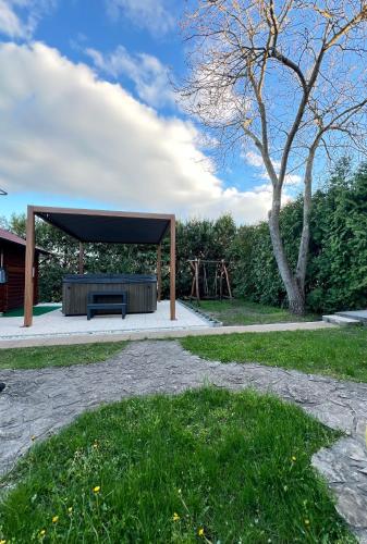 a picnic shelter with a bench in a park at Pellegrini Apartman in Balatonakali