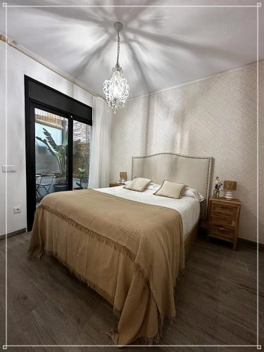 a bedroom with a large bed and a chandelier at Blanes Playa in Blanes