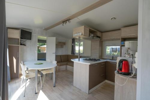 a small kitchen with a white table and a table and chairs at Ty Névez in Trégunc