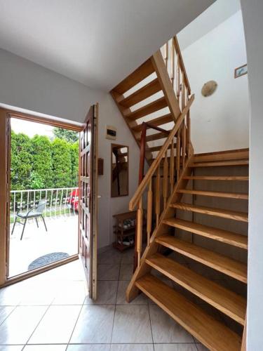 a wooden staircase in a room with a sliding glass door at Apartment Balatonfenyves in Balatonfenyves