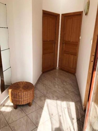 a hallway with two wooden doors and a stool at Apartment Balatonfenyves in Balatonfenyves