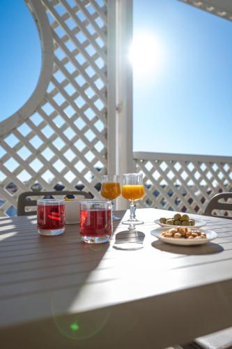 - une table avec deux verres de vin et une assiette de nourriture dans l'établissement Résidence Odalys Les Terrasses de Fort Boyard, à Fouras