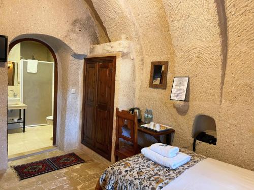 a bedroom with a bed and a sink in a room at Gedik Cave Hotel in Goreme