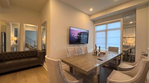 a dining room with a table and a tv on the wall at French Style Mansion In Prestigious Angus Glen Markham in Markham