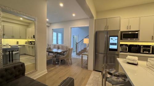 a kitchen and a living room with a dining table and a kitchen at French Style Mansion In Prestigious Angus Glen Markham in Markham