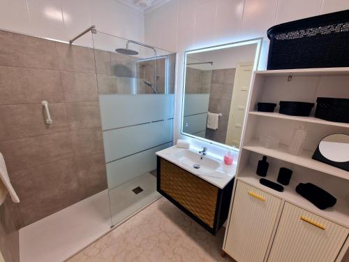 une salle de bain avec une douche, un lavabo et un miroir dans l'établissement Tranquil Bungalow Retreat, à Ciudad Quesada