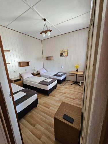 a room with two beds and two tables at Leśna Osada Tęcza Jabłonowiec in Jabłonowiec