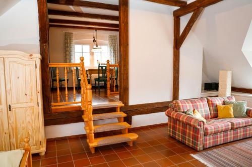a living room with a staircase and a couch at Mühlenhof in Olbersdorf