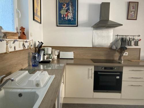 une cuisine avec un évier et une cuisinière dans l'établissement Chez Tipoulot - maison de pêcheur à 2 pas du port, à Fécamp