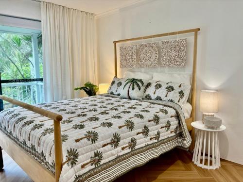 a bedroom with a large bed with palm trees on it at The Nines Noosa in Noosaville