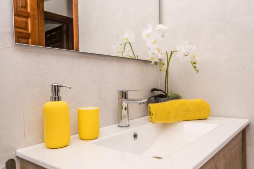 - un lavabo dans la salle de bains avec deux distributeurs de savon jaune dans l'établissement Casa Golondrina, à Moraira