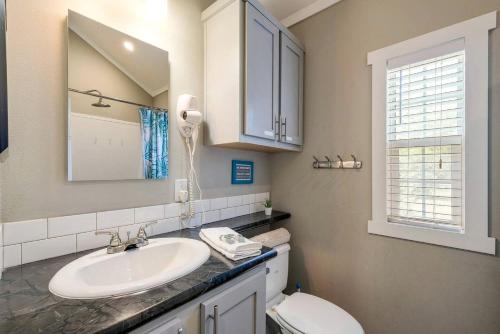 a bathroom with a sink and a toilet and a mirror at Riverfront Tiny House with Fire Pit in Seguin, Texas in Seguin