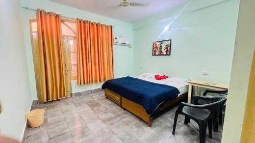 a bedroom with a bed and a desk and a table at Hotel Laxman Ganga in Rishīkesh