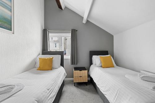 two beds in a room with white and yellow pillows at Imperial Plymouth in Plymouth