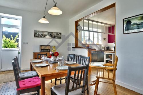 une salle à manger avec une table et des chaises en bois dans l'établissement LocaLise - M6A - Ty Heol - Maison de vacances à quelques pas du port et des plages - jardin avec terrasse entièrement clos - wifi inclus, à Tréffiagat