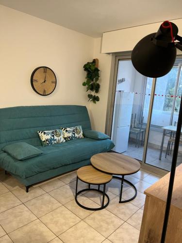 un salon avec un canapé vert et une table dans l'établissement Le lagon bleu piscine et tennis, à Fréjus